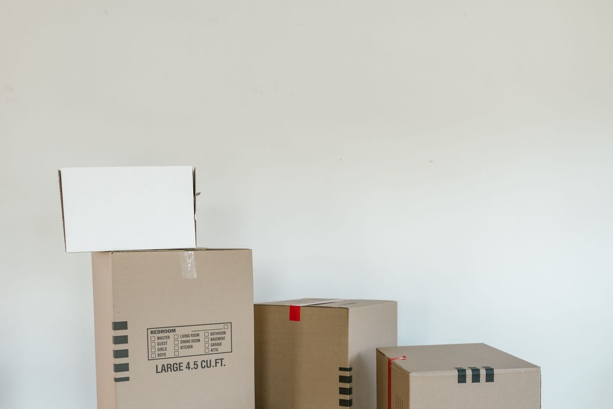Stacked moving cartons sealed and labelled, ready for collection